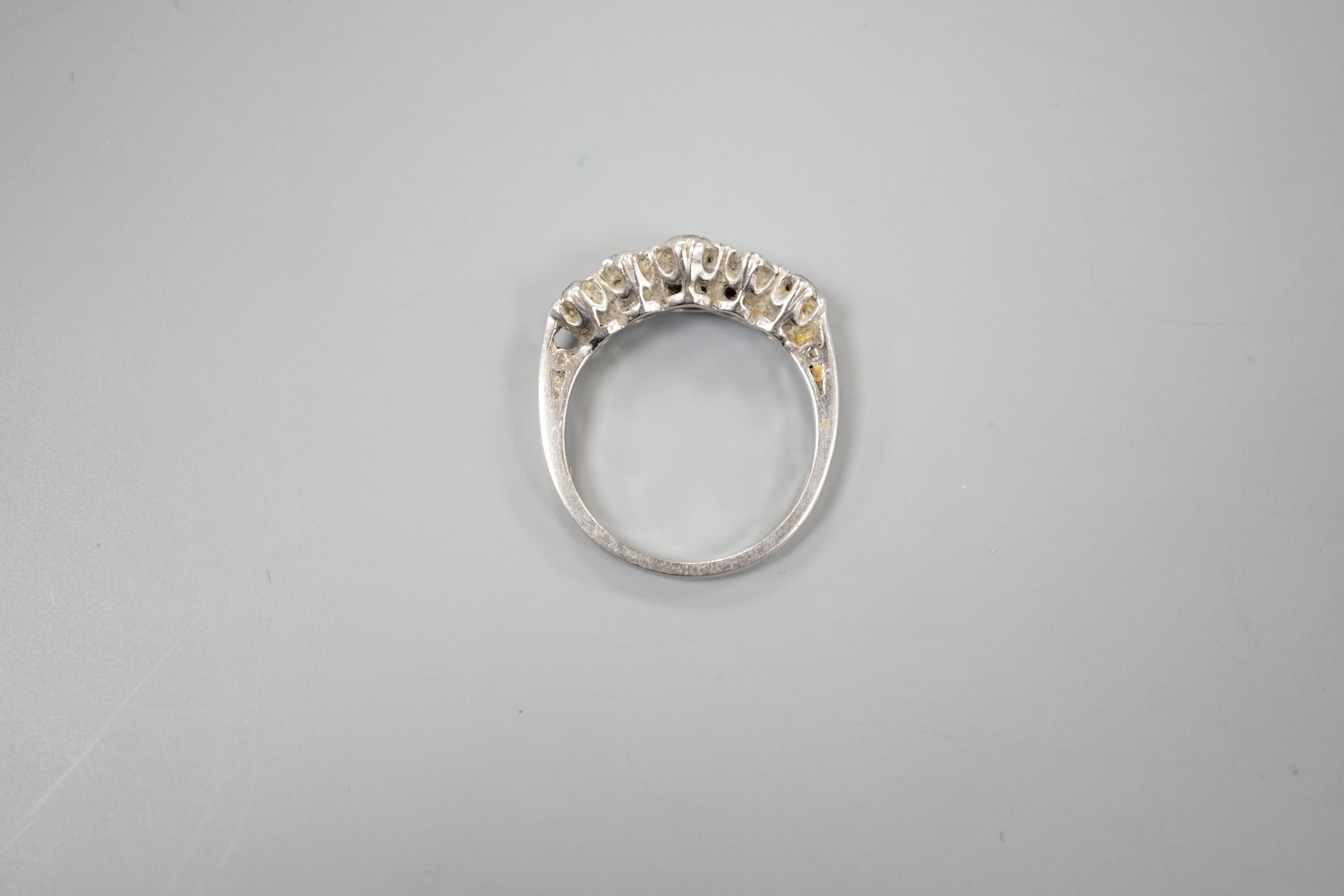 A modern platinum and graduated five stone diamond set half hoop ring, size P/Q, gross weight 6 grams.